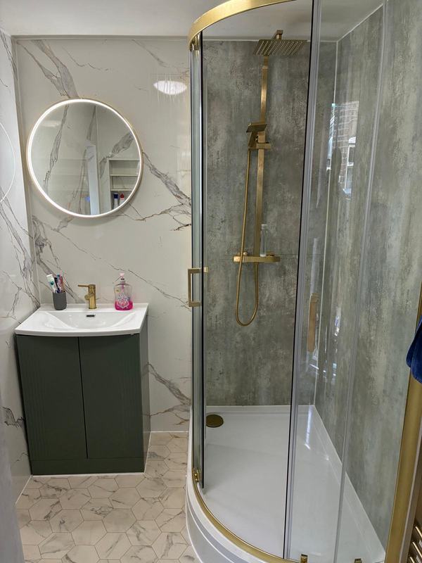 Master ensuite with LED-lit circular mirror and gold fixtures